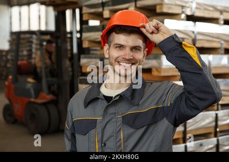 Portrait of cheerful male worker on metal stock. Stock Photo