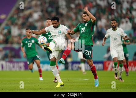 Saudi Arabia's Ali Al-Bulaihi (left) and Mexico's Henry Martin battle for the ball during the FIFA World Cup Group C match at the Lusail Stadium in Lusail, Qatar. Picture date: Wednesday November 30, 2022. Stock Photo