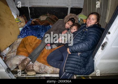 Djurdja Hudorovic with her grandchildren in the van where they will spend the night. Several families spend the night in cars and vans on the basketball court. A lot of people have lost their homes, and many cannot enter them due to damage. A strong earthquake hit Croatia yesterday, the epicenter of the 6.2 magnitude earthquake was 3 kilometers from Petrinja, in Glina, Croatia, on December 30, 2020. Photo: Davor Puklavec/PIXSELL Stock Photo