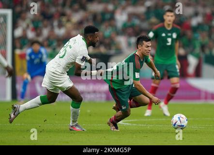 Saudi Arabia's Riyadh Sharahili (left) and Mexico's Hirving Lozano battle for the ball during the FIFA World Cup Group C match at the Lusail Stadium in Lusail, Qatar. Picture date: Wednesday November 30, 2022. Stock Photo