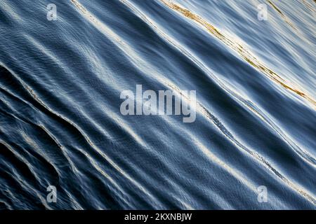 Ripples on blue sea from a passing boat. backgrounds, No people. Copy space. Stock Photo