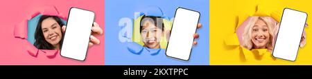Three beautiful women showing cell phones through hole in wall Stock Photo