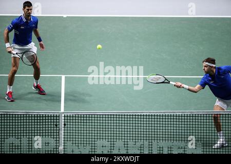 MADRID, SPAIN - DECEMBER 03: Filip Krajinovic of Serbia plays a forehand shot as teammate Novak Djokovic of Serbia looks on against Mate Pavic and Nikola Mektic of Croatia during the Davis Cup Semi Final match between Croatia and Serbia at Madrid Arena on December 03, 2021 in Madrid, Spain. Photo: Sanjin Strukic/PIXSELL Stock Photo