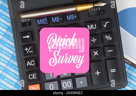 Finance and economics concept. On the desktop are charts, reports, a calculator and a sheet for notes on which it is written - Quick Survey Stock Photo