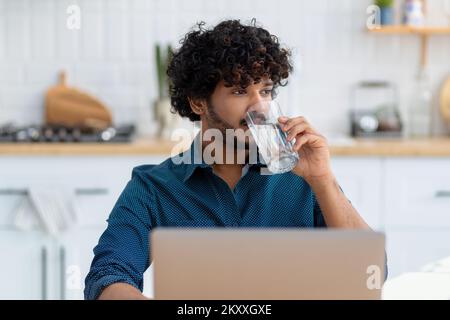 male freelancer or employee sitting at workplace, coworking. man using laptop computer working at home Stock Photo
