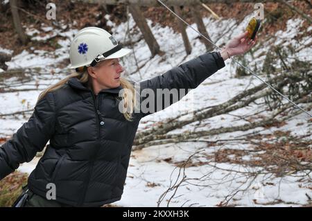 Parsons, W.Va., Nov. 5, 2012   Jennifer Rabuck, a U.S. Forest Service worker from the Chequamegon-Nicolet National Forest in Wisconsin, verifies that a downed power line in West Virginia's Tucker County is safe before a tree trimming crew starts clearing downed trees so that power can be restored. FEMA is working with state, federal and local partners to assist residents of the state affected by the deep snow, heavy rain and high winds of Hurricane Sandy. Norman Lenburg/FEMA. West Virginia Hurricane Sandy. Photographs Relating to Disasters and Emergency Management Programs, Activities, and Off Stock Photo