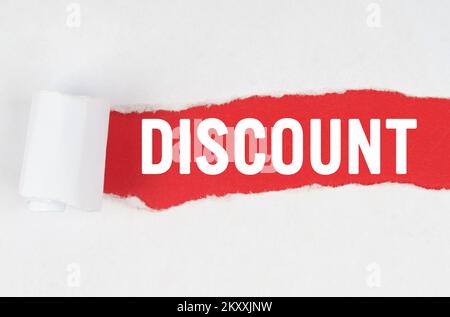 Business and finance. Behind torn white paper on a red background, the text - DISCOUNT Stock Photo