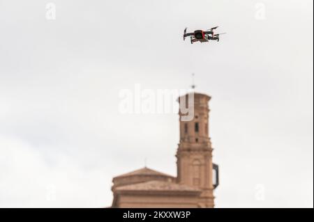 Video recording quadcopter drone flying in a clear sky near a church Stock Photo