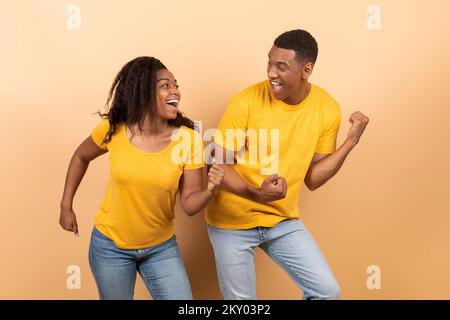 Having fun. Portarit of joyful black couple dancing and fooling around, enjoying favorite music together Stock Photo