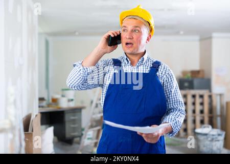 Construction worker having telephone conversation Stock Photo