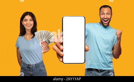 Overjoyed arab couple holding a lot of cash and smartphone Stock Photo