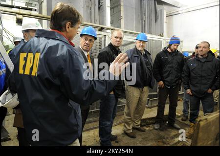 Sayerville, N.J., Nov. 28, 2012   U.S. Environmental Protection Agency on-scene coordinator for Region II, Cris D'Onofrio, explains the efforts used to restore the water pumping station during Hurricane Sandy to FEMA Administrator Craig Fugate, third from and Commissioner of NJ Environmental Protection Bob Martin, center, at the local Water Pumping Station. Local officials as well as the divers who were responsible for putting the gates back in position briefed the Administrator. The station was underwater during the storm. Sayerville, NJ, Nov. 28, 2012--US Environmental Protection Agency on-s Stock Photo