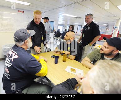 New York, N.Y., Dec. 1, 2012   Federal Coordinating Officer Michael Byrne, standing, left, talks to Surge volunteers from Transportation Security Association (TSA) and US Coast Guard in the Massachusetts Maritime Academy Relief Ship, TS Kennedy mess hall. Volunteers from a number of agencies who have come to help with community relations activities in response to Hurricane Sandy have sleeping accommodations on the ship. New York, NY, Dec. 1, 2012--Federal Coordinating Officer Michael Byrne, standing, left, talks to SURGE volunteers from Transportation Security Association (TSA) and US Coast Gu Stock Photo