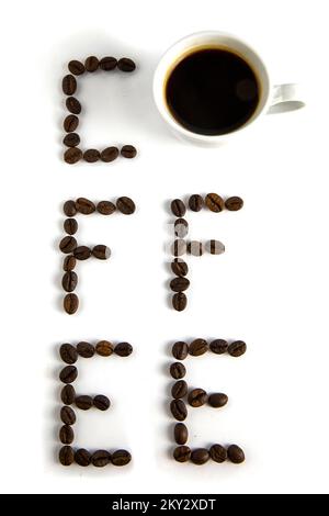 A cup of coffee on a white table, an inscription from coffee. Stock Photo
