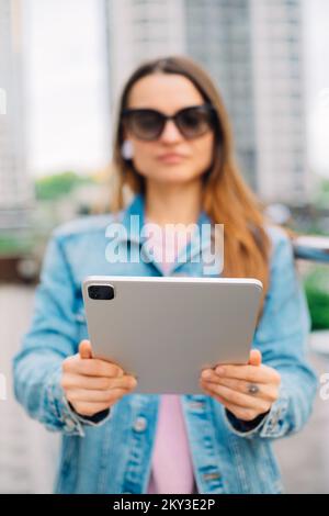 Young business woman millennials in glasses walking Financial District city uses digital tablet in Social networks, Connection, Data, Digital display Stock Photo