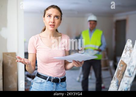 Annoyed woman architect standing at renovating object Stock Photo