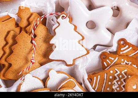 View of the unpacked christmas present with sweets inside white paper packaging, close-up with selective focus Stock Photo