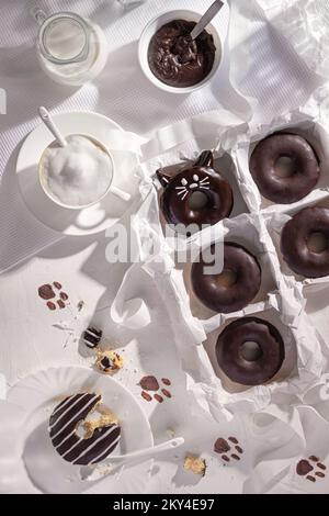 Glazed chocolate funny donuts and cup of cappuccino on stone background. Top view. Flat lay composition Stock Photo