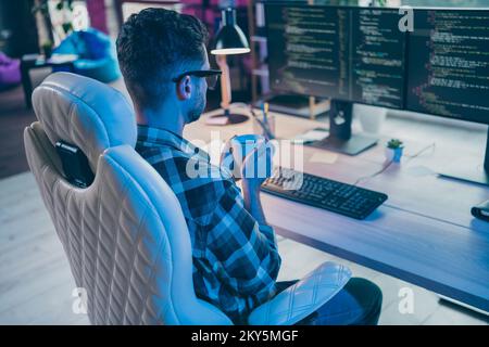 Photo of thoughtful busy programmer wear spectacles drinking tea thinking working modern device indoors workplace workshop home Stock Photo
