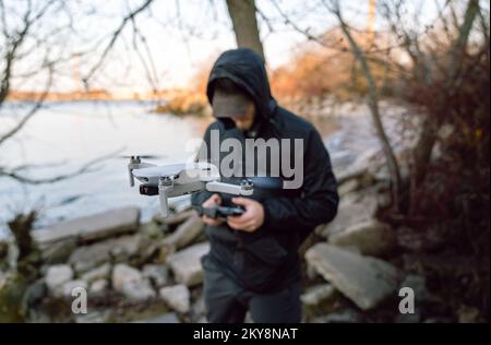 A young man launches a mini drone into the air Stock Photo