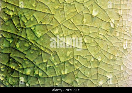 Close up to background and texture of stretch marks cracked on emerald green glazed tile. Scratches background. Vintage scratched grunge tile broken s Stock Photo