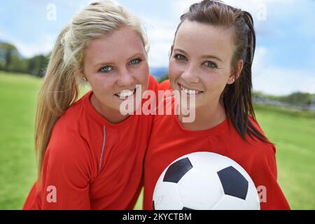 The teams start players. Portrait of two young female soccer players standing on a soccer field. Stock Photo