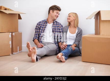 Taking a quick break before unpacking. a happy young couple on their moving in day. Stock Photo