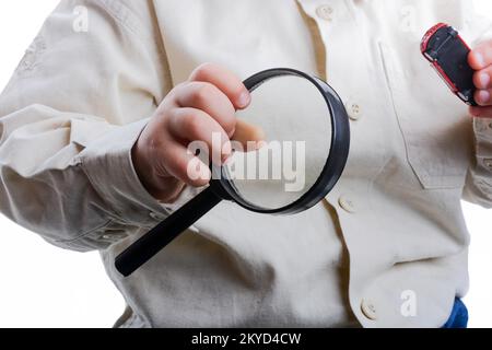 Baby holding a magnifying glass in hand on a white background Stock Photo