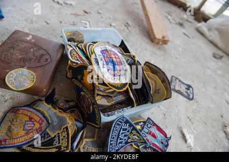 Stacks of police force patches from around the world, damaged by the 2016 historic flooding in Louisiana, sit on the ground in the gutted home of Walter and Melanie Daisey in Walker, La. Walter collected the patches during his 32 years in the police force; he retired as the Assistant Chief of Police in Walker after becoming the first K-9 police officer in Livingston Parish. Although his patches remain, Melanie stated this his badges vanished in aftermath of the flooding, presumably stolen by looters. They received approximately four feet of water inside of their home.. Louisiana Severe Storms Stock Photo