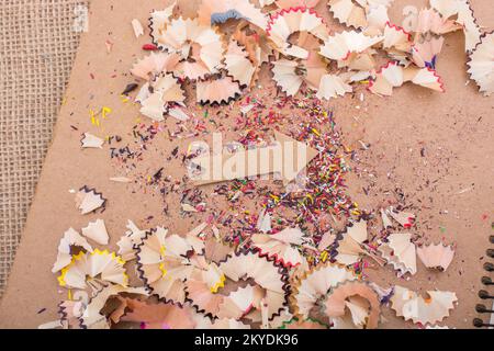 Arrow cut out of paper amid pencil shavings on canvas Stock Photo