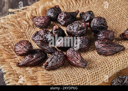 Dried mission figs on burlap and wooden background. Stock Photo