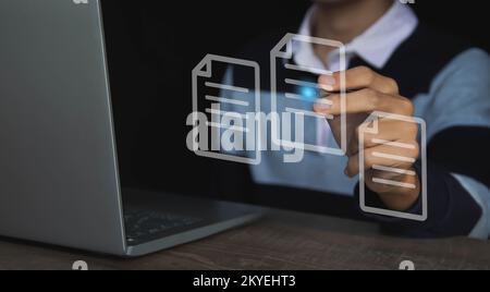Use a computer with virtual screens and documents to approve paperless documentation and ERP management concepts online. Stock Photo
