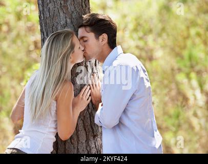 Caught up in the romance. A beautiful young couple showing their affection in the park. Stock Photo