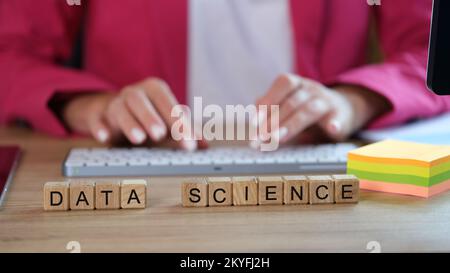 Words data science on wooden cubes and female scientist working with data on computer. Stock Photo