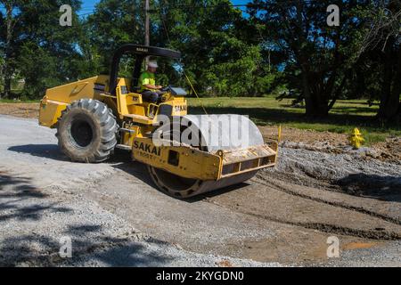 Biloxi, MS, May 6, 2015 - Using a heavy equipment compactor, a construction worker from Oscar Renda Contracting prepares a road bed for the paving of new asphalt on 8th Street in Biloxi, MS. The restoration of Biloxi's water and sewer infrastructure (including the resurfacing of affected streets) is Mississippi's largest FEMA Public Assistance project related to the Hurricane Katrina recovery effort. Stock Photo