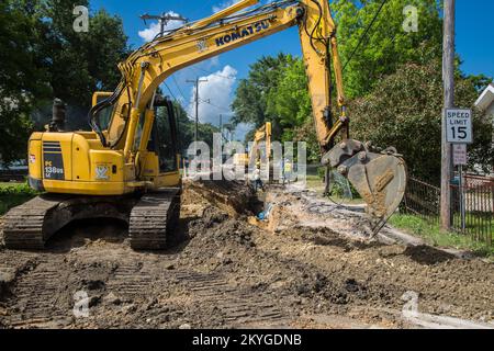 Biloxi, MS, May 6, 2015 - Using heavy equipment excavators, construction workers from S.J. Construction of Texas excavate a road for the installation of a new water line under Nixon Street (near Division Street) in Biloxi, MS. The restoration of Biloxi's water and sewer infrastructure is Mississippi's largest FEMA Public Assistance project related to the Hurricane Katrina recovery effort. Stock Photo