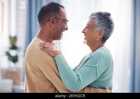 Happy, love and romance with a senior couple laughing, hugging or dancing together in their home. Dance, romantic and smile with a happy mature man Stock Photo