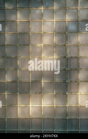 San Antonio, Texas- Cube glass panels of a window in a close-up view. Old window with square thick glass panels and yellow sun glow. Stock Photo