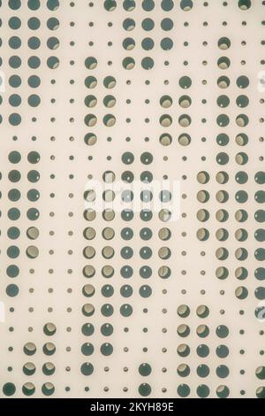 San Antonio, Texas- Beige perforated metal sheet wall. Close-up of a metal wall with decorative holes pattern creating a shadow at the background. Stock Photo