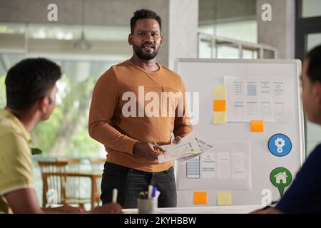 Portrait of UI designer presenting his ideas to colleagues at Meeting Stock Photo