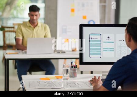 UI designer working on computer, creating interface for mobile application Stock Photo
