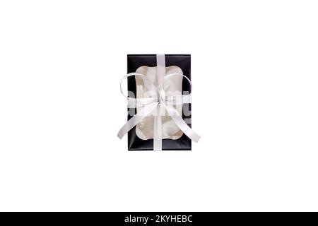 Black gift box with silver ribbon isolated on white background flat lay, top view. Monochrome colors trendy present. Paper package with transparent wi Stock Photo