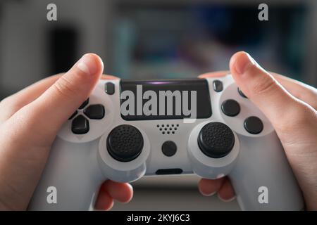 Male hands hold modified plastic joystick closeup, selective focus. Person play videogames. Hold wireless game console. Press buttons on controller by Stock Photo