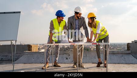 Group of engineers, architects, business partners at construction site working together Stock Photo