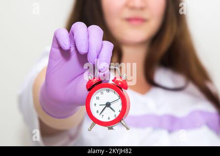 Cropped view of woman holding alarm clock  Stock Photo