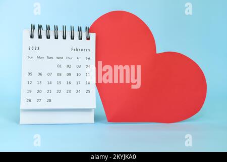 Selective focus of February 2023 desk calendar with big red heart shape on blue background with copy space. Stock Photo