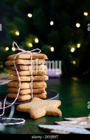 Homemade Christmas cookies in the shape of a star on the dark green background Stock Photo