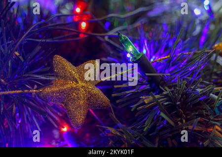 Star-shaped Christmas baubles hanging on a Christmas tree in Poland Stock Photo