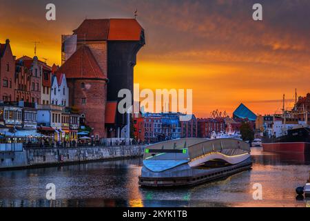 City skyline of Gdansk Old Town with the Crane and golden sky at the Motlawa River in Poland. Stock Photo