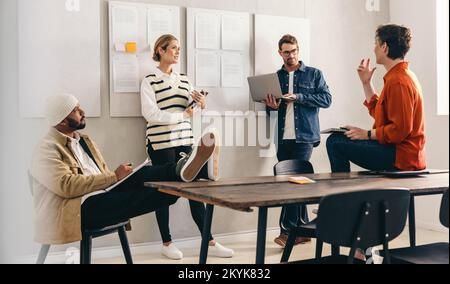 Creative business team having a group discussion during a meeting in a boardroom. Diverse businesspeople sharing ideas while working together in a mod Stock Photo
